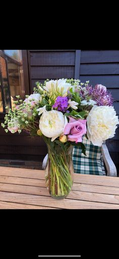 a vase filled with flowers sitting on top of a wooden table