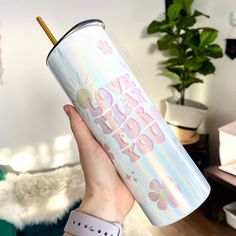 a person holding up a pink and white tumbler with the words happy new year on it