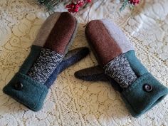 two mittens sitting on top of a table next to a christmas tree