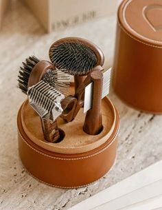 two small hairbrushes and combs are in a box on the floor next to each other