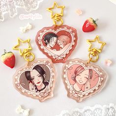 three key chains with pictures of two women on them and strawberries in the background