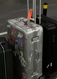 two pieces of luggage sitting next to each other on the ground with stickers all over them