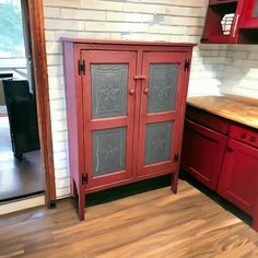 a red cabinet in the corner of a kitchen