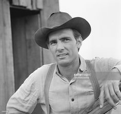 black and white photograph of a man wearing a cowboy hat with his hand on his hip