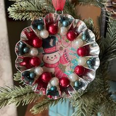 a christmas ornament hanging from a tree with ornaments on it's side