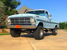 an old blue truck is parked in the driveway