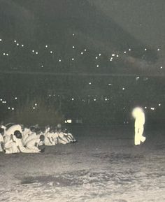 a group of people sitting on the ground in front of an audience at a sporting event