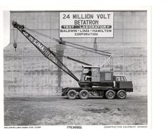 a black and white photo of a crane in front of a sign that reads 25 million volt