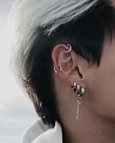 a person with some piercings on their ears and ear rings in front of them