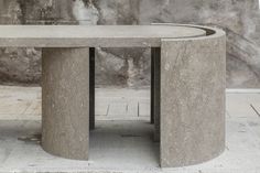 a concrete table sitting on top of a cement floor next to a stone wall and steps