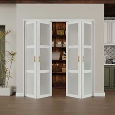 the interior of a kitchen with two white doors open to reveal a pantry and dining room