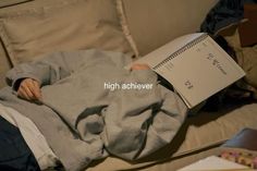 a person laying on a couch with a book in their lap and the words high achieve above them