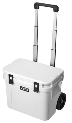 the yeti wheeled cooler is white and has wheels on each side with black handles