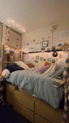 a bed room with a neatly made bed and lots of lights on the wall above it