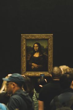 people are looking at a painting on display