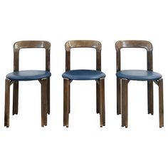 three wooden chairs with blue leather seats