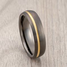 a wedding ring with two tone gold inlays on the inside of it, sitting on a gray surface