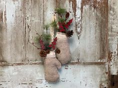 two christmas stockings hanging on a wall with pine cones and evergreen needles attached to them