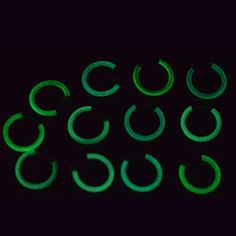 green glow in the dark earrings on a black background, with small circular shapes that appear to be interlocked together