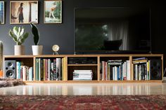 a living room filled with furniture and a flat screen tv sitting on top of a wooden shelf