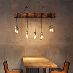 a wooden table with chairs and lights hanging from it