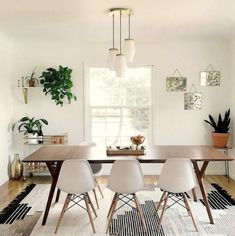 a dining room with white chairs and a wooden table