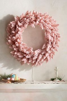 a pink wreath sitting on top of a mantle