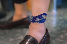 a close up of a person's foot with a blue and white tattoo on it