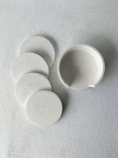 five white ceramic dishes sitting on top of a table