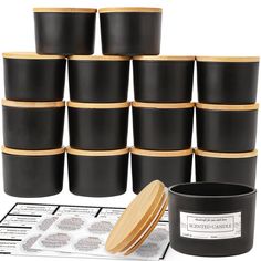 a stack of black cups with wooden lids next to a pile of labels and stickers