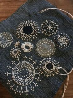 an old piece of cloth with different designs on it and some thread in the middle