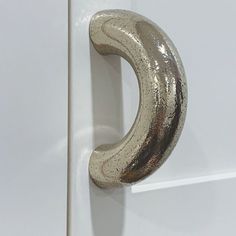 a close up of a door handle on a white door with gold foiled paint