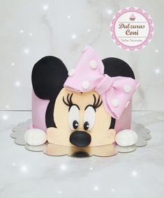 a cake shaped like a minnie mouse with a pink bow on it's head