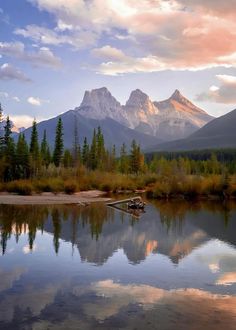 the mountains are reflected in the still water