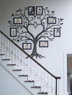 a family tree on the wall next to stairs with pictures hanging from it's branches