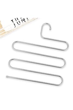 three metal clothes hangers next to a ruler