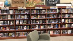 a chair sitting in front of a bookshelf filled with lots of different types of books