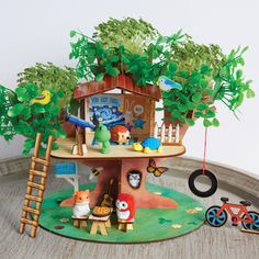 a toy tree house with animals and plants