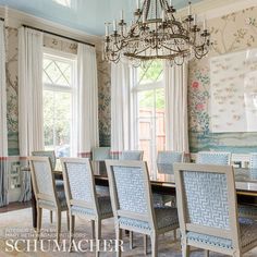 a dining room table with chairs and a chandelier hanging from it's ceiling