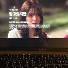 a laptop computer with an image of a woman on it's screen and korean characters in the background