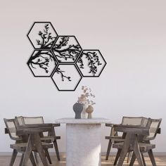 a dining room table with chairs and a vase on the table in front of it