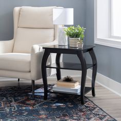 a living room with a chair, table and lamp