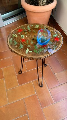 a glass table sitting on top of a tiled floor next to a potted plant