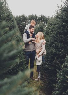 a family standing in a christmas tree farm