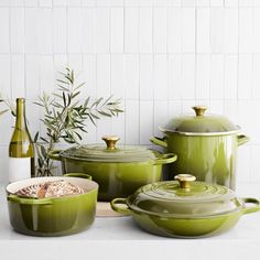 green pots and pans are sitting on the counter