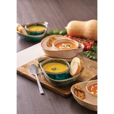 bowls of soup and bread on a cutting board