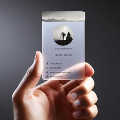 a person holding up a business card with the image of a photographer on it in their hand