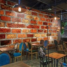 an empty restaurant with brick walls and blue chairs