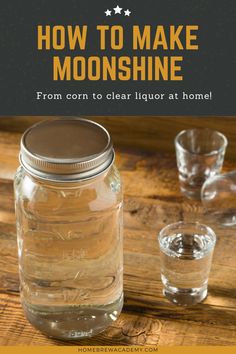 a mason jar filled with clear liquid sitting on top of a wooden table next to two glasses