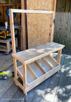 a wooden bench sitting on top of a hard wood floor next to a building under construction